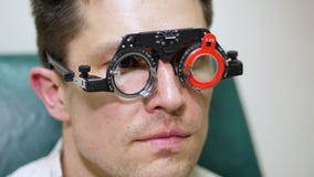 Stellen Sie Nahaufnahme, den Augenarzt gegenüber, der geduldigen Mann mit Optometrikerproberahmen, Sichtprüfungsgerät überprüft m stock footage Stellen Sie Nahaufnahme, den Augenarzt gegenüber, der geduldigen Mann mit Optometrikerproberahmen, Sichtprüfungsgerät überprüft m stock footage