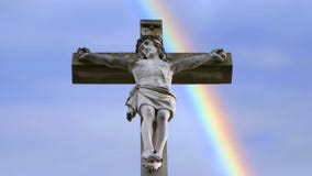 Stena korset med Jesus och blå himmel med regnbågen arkivbilder Stena korset med Jesus och blå himmel med regnbågen arkivbilder