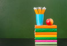 Sterta blisko książki z jabłkiem i ołówki opróżniamy zielonego chalkboard Zdjęcie Stock Sterta blisko książki z jabłkiem i ołówki opróżniamy zielonego chalkboard Zdjęcie Stock
