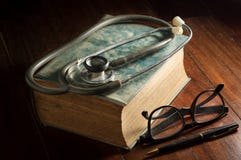 Stethoscope with eyeglasses,pen and antique book. royalty free stock photography Stethoscope with eyeglasses,pen and antique book. royalty free stock photography