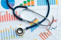 Stethoscope on healthcare stats and financial analysis charts