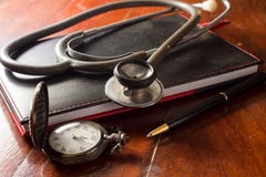 Stethoscope with pocket watch,book and pen stock images Stethoscope with pocket watch,book and pen stock images