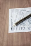 Steuerformular 1040 und Stift auf dem Tisch lizenzfreies stockbild Steuerformular 1040 und Stift auf dem Tisch lizenzfreies stockbild
