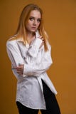 Stilfull ung flicka med lockigt h?r och att le cutely som poserar, p? gul bakgrund arkivfoto Stilfull ung flicka med lockigt h?r och att le cutely som poserar, p? gul bakgrund arkivfoto