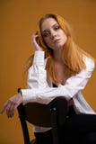 Stilfull ung flicka med lockigt h?r och att le cutely som poserar, p? gul bakgrund royaltyfri bild Stilfull ung flicka med lockigt h?r och att le cutely som poserar, p? gul bakgrund royaltyfri bild