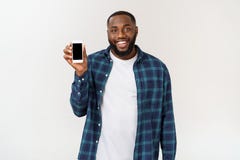 Stilig afrikansk amerikanman som isoleras på grå bakgrund som framlägger den smarta telefonen arkivbilder Stilig afrikansk amerikanman som isoleras på grå bakgrund som framlägger den smarta telefonen arkivbilder
