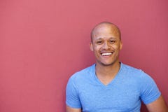 Stilig afrikansk amerikanman som ler mot röd bakgrund fotografering för bildbyråer Stilig afrikansk amerikanman som ler mot röd bakgrund fotografering för bildbyråer