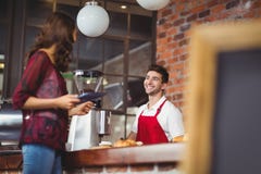 Stilig barista som diskuterar med en kund royaltyfri fotografi Stilig barista som diskuterar med en kund royaltyfri fotografi