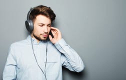 Stilig bärande hörlurar för ung man och lyssna till musik fotografering för bildbyråer Stilig bärande hörlurar för ung man och lyssna till musik fotografering för bildbyråer