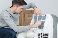 Stilig elektriker för ung man som installerar luft som betingar i klienthus royaltyfri foto Stilig elektriker för ung man som installerar luft som betingar i klienthus royaltyfri foto