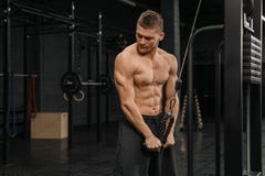 Stilig grabbutbildningstriceps i idrottshallen som upp pumpar kroppbodybuildingidrottsman nen arkivfoton Stilig grabbutbildningstriceps i idrottshallen som upp pumpar kroppbodybuildingidrottsman nen arkivfoton
