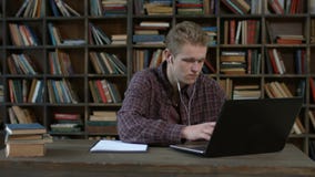 Stilig student med bärbar dator e som hemma lär arkivfilmer Stilig student med bärbar dator e som hemma lär arkivfilmer