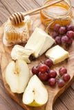Still life with cheese, grape and honey