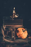 Still life for Halloween and Thanksgiving with old books, pumpkins and candle