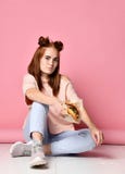 Stilvolles und junges Ingwer Frauengriff-Burgersandwich auf rosa Hintergrund stockbild Stilvolles und junges Ingwer Frauengriff-Burgersandwich auf rosa Hintergrund stockbild