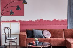 Stol med tidskrifter bredvid den bruna hörnsoffan med kuddar i vit och den burgundy inre royaltyfri bild Stol med tidskrifter bredvid den bruna hörnsoffan med kuddar i vit och den burgundy inre royaltyfri bild