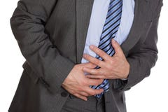 Stomach ache. Businessman holding his stomach in pain or indigestion Stomach ache. Businessman holding his stomach in pain or indigestion