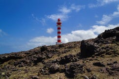 Stony landscape with white and red lighthouse and blue sky with stock photos Stony landscape with white and red lighthouse and blue sky with stock photos