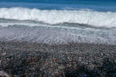 Stony ocean coast washed by the sea surf. Waves breaking on boulders on shore. Waves turn into a sea foam. stock photography Stony ocean coast washed by the sea surf. Waves breaking on boulders on shore. Waves turn into a sea foam. stock photography