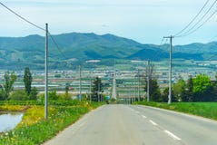 Strada asfaltata della strada principale di velocità fra i campi nel giorno luminoso di alba immagini stock libere da diritti Strada asfaltata della strada principale di velocità fra i campi nel giorno luminoso di alba immagini stock libere da diritti