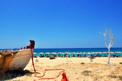 Strandparaplu's, wit vergoelijkt boom en deel van boot mooi landschap in zonnige de zomerdag op Naxos-eiland royalty-vrije stock fotografie Strandparaplu's, wit vergoelijkt boom en deel van boot mooi landschap in zonnige de zomerdag op Naxos-eiland royalty-vrije stock fotografie