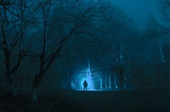 Strange Silhouette In A Dark Spooky Forest At Night, Mystical Landscape Surreal Lights With Creepy Man Royalty Free Stock Images
