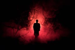 Strange Silhouette In A Dark Spooky Forest At Night, Mystical Landscape Surreal Lights With Creepy Man. Toned Stock Photography Strange Silhouette In A Dark Spooky Forest At Night, Mystical Landscape Surreal Lights With Creepy Man. Toned Stock Photography