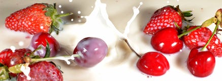 Strawberries and Cherries dropping into milk stock image Strawberries and Cherries dropping into milk stock image