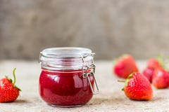 Strawberry jam in a glass jar on the table Stock Images Strawberry jam in a glass jar on the table Stock Images