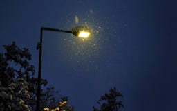 Straßenlaterne in einer Nacht des verschneiten Winters Herzenswärme von Straßenlaterneumgeben durch Schneeflocken Lizenzfreie Stockbilder Straßenlaterne in einer Nacht des verschneiten Winters Herzenswärme von Straßenlaterneumgeben durch Schneeflocken Lizenzfreie Stockbilder