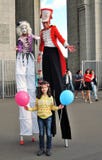 Street actors walk on stilts and pose for photos in Moscow