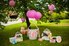 Street decorations for a children`s party. Wicker baskets with balloons in a green park