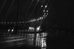 Street lights and car headlights on the wet street with rain water all over Royalty Free Stock Photo Street lights and car headlights on the wet street with rain water all over Royalty Free Stock Photo