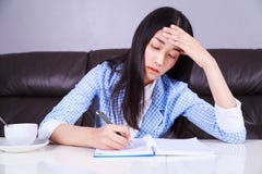 Stressed business woman sitting at her desk and writes a note on royalty free stock images Stressed business woman sitting at her desk and writes a note on royalty free stock images