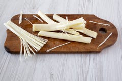 String cheese on rustic wooden board, side view. Healthy snack. royalty free stock photo String cheese on rustic wooden board, side view. Healthy snack. royalty free stock photo