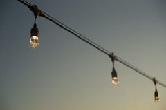 String of three bulb lights in front of the sky