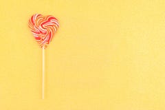 Striped в форме сердц леденец на палочке на предпосылке золота стоковые изображения rf Striped в форме сердц леденец на палочке на предпосылке золота стоковые изображения rf