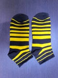 Striped носки младенца с черными и желтыми нашивками стоковое фото rf Striped носки младенца с черными и желтыми нашивками стоковое фото rf