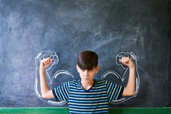 Strong Male Child Showing Muscles In Classroom At Lesson Royalty Free Stock Photo Strong Male Child Showing Muscles In Classroom At Lesson Royalty Free Stock Photo