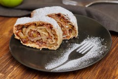 Strudel της Apple με τη ζάχαρη τήξης στο μαύρο πιάτο, ξύλινο υπόβαθρο στοκ εικόνες Strudel της Apple με τη ζάχαρη τήξης στο μαύρο πιάτο, ξύλινο υπόβαθρο στοκ εικόνες