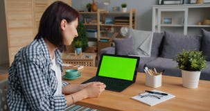 Studencki młodej damy dopatrywania laptop z zieleń ekranem ono uśmiecha się w mieszkaniu zdjęcie wideo Studencki młodej damy dopatrywania laptop z zieleń ekranem ono uśmiecha się w mieszkaniu zdjęcie wideo