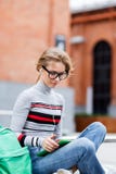 Student sits on bench and looking at Tablet-PC royalty free stock photography Student sits on bench and looking at Tablet-PC royalty free stock photography