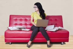 Student sitting on sofa while doing homework royalty free stock images Student sitting on sofa while doing homework royalty free stock images
