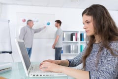 Student som tar anmärkningar med bärbara datorn i grupp i universitet royaltyfri fotografi Student som tar anmärkningar med bärbara datorn i grupp i universitet royaltyfri fotografi