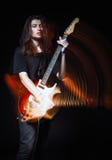 Studio portrait: handsome young long-haired man rock musician playing the electric guitar. Blurry motion effect Stock Photos Studio portrait: handsome young long-haired man rock musician playing the electric guitar. Blurry motion effect Stock Photos