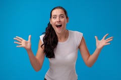 Studio portrait of a young beautiful woman in a white t-shirt against a blue wall background. People sincere emotions. stock photography Studio portrait of a young beautiful woman in a white t-shirt against a blue wall background. People sincere emotions. stock photography
