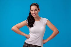 Studio portrait of a young beautiful woman in a white t-shirt against a blue wall background. People sincere emotions. stock photography Studio portrait of a young beautiful woman in a white t-shirt against a blue wall background. People sincere emotions. stock photography