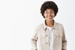 Studio shot of creative confident and carefree dark-skinned female freelancer in beige shirt and glasses holding hands royalty free stock image Studio shot of creative confident and carefree dark-skinned female freelancer in beige shirt and glasses holding hands royalty free stock image