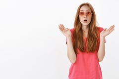 Studio shot of impressed and amazed stylish good-looking redhead girl with freckles raising spread palms and gasping royalty free stock photo Studio shot of impressed and amazed stylish good-looking redhead girl with freckles raising spread palms and gasping royalty free stock photo