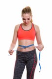 Studio shot of young beautiful teenage girl measuring waist whil royalty free stock photo Studio shot of young beautiful teenage girl measuring waist whil royalty free stock photo